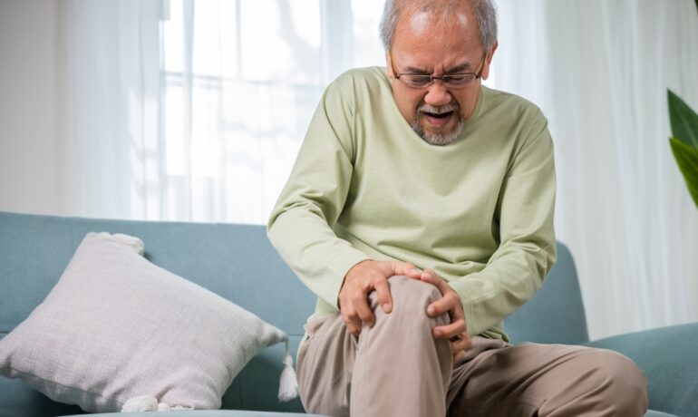 Man holding knee due to osteoporosis pain.